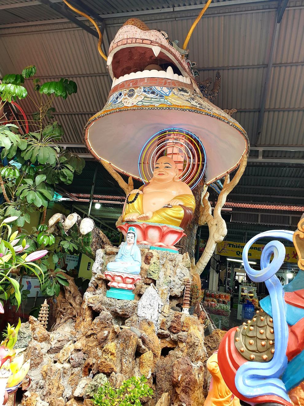 Đầu rồng khảm sành sứ há miệng, bên trong đặt pho tượng Phật Di Lặc